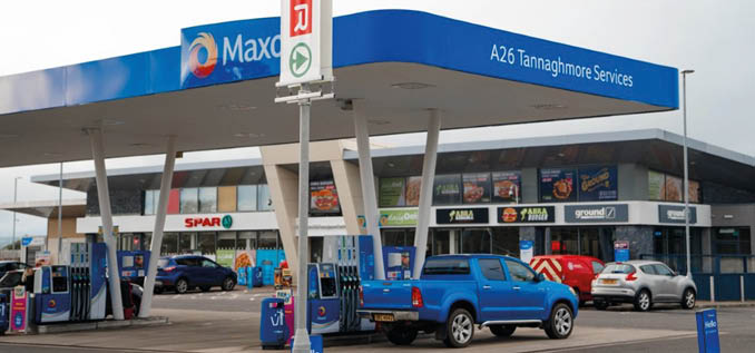A gas station with a blue sign and a red truck parked in front of it. AI generated content