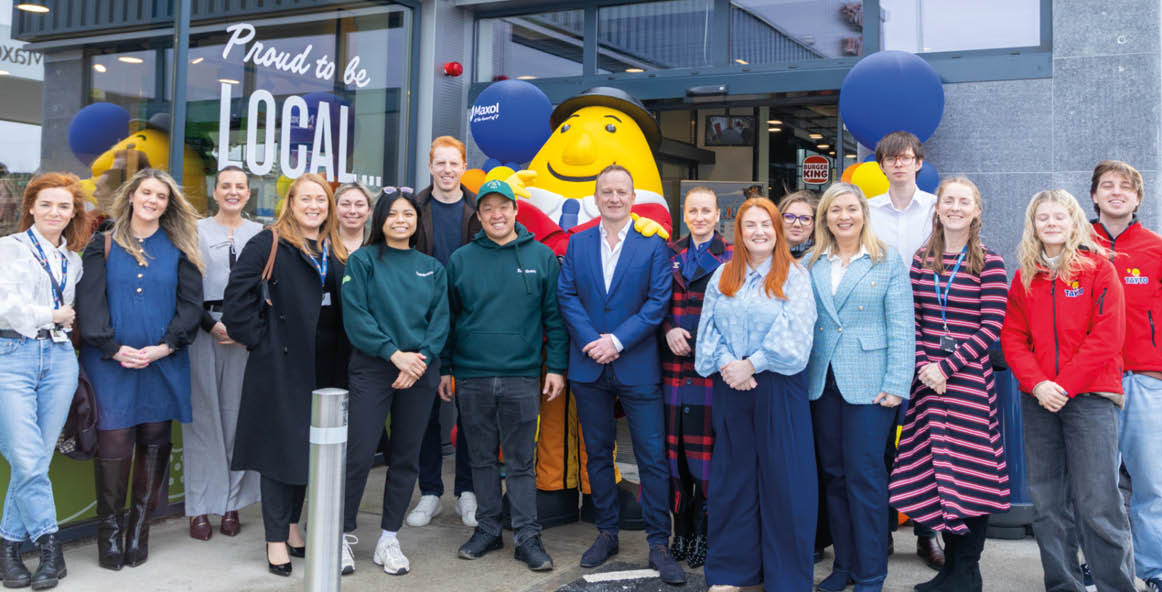 A group of people standing in front of a building. Description generated by AI