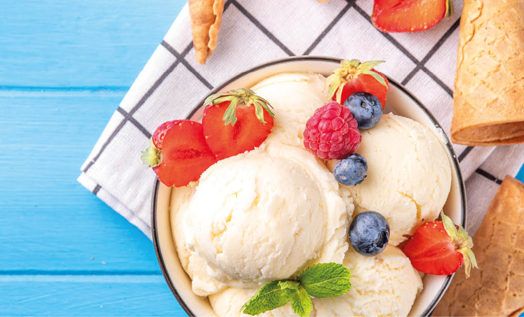 White ice cream bowl with vanilla gelato and fresh berries. Big portion of classic vanilla taste ice cream, with strawberry, raspberry, blueberry, blackberry, and waffle ice cream cones