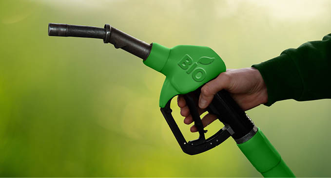 Hand with fuel nozzle with inscription BIO. Carbon neutral bio fuel decarbonization concept