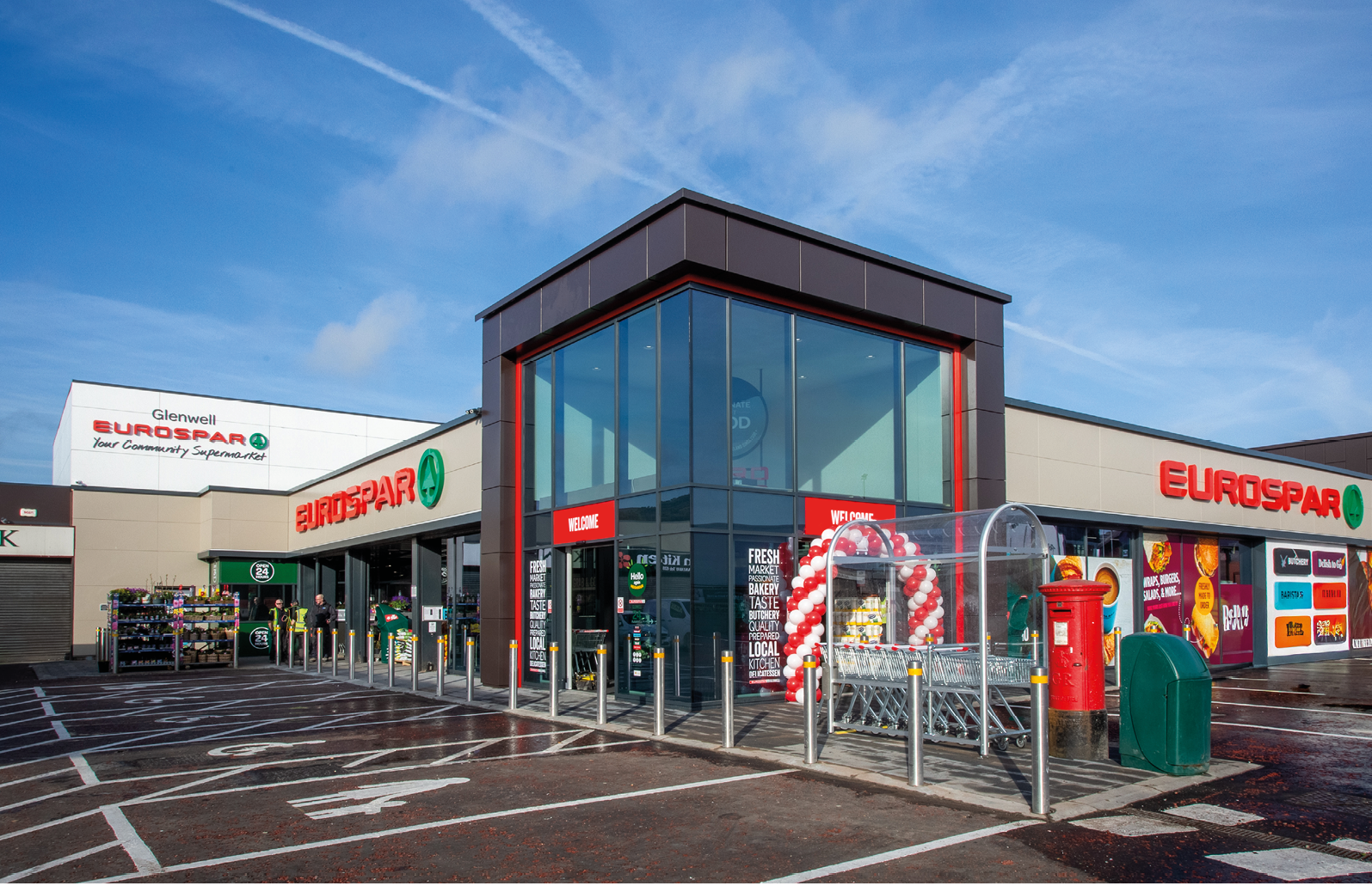 A large building with a red roof and a green box. Description generated by AI