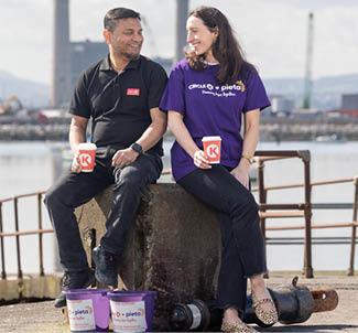 Two people sitting on a concrete block. Description generated by AI