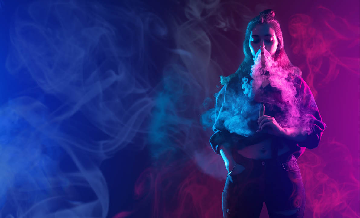 A woman smoking a cigarette in a pink and blue room. Description generated by AI
