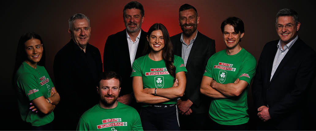 A group of people in green shirts and black pants. Description generated by AI