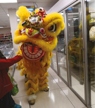 A yellow and red dragon statue is in a store. Description generated by AI