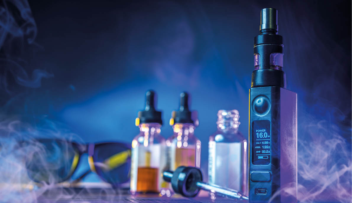 Vape device. Electronic cigarette. Vape oils on table. E-cig in smoke. Vaping devices in neon light. Vape kit for smokers. Vaper gadget. Device for tobacco-free smoking. Alternative to cigarettes