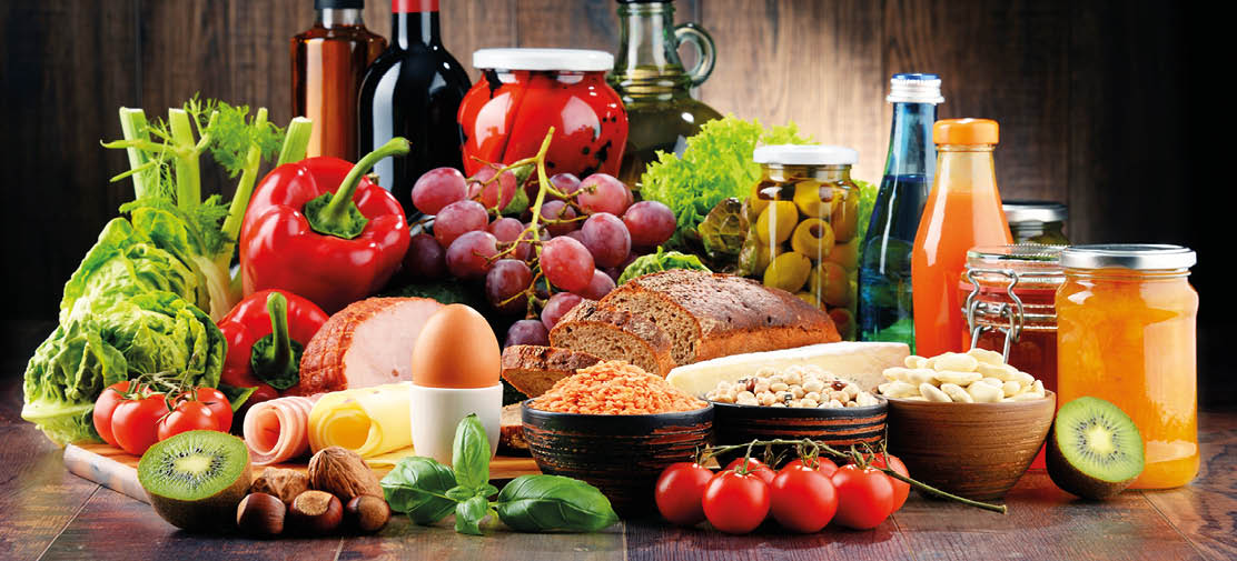 Composition with variety of organic food products on kitchen table