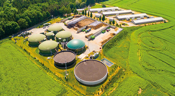 Aerial view over biogas plant and farm in green fields. Renewable energy from biomass. Modern agriculture in Czech Republic and European Union. 