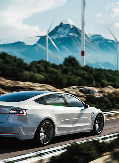 Electric car drive on the wind turbines background. Car drives along a mountain road. Electric car driving along windmills farm. Alternative energy for cars. Car and wind turbines farm. 3d render