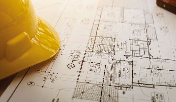 Vintage business desk of engineer contractor with equipment, blueprint, safety helm and object.