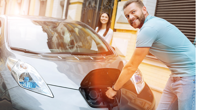 Smiling man unplugging the charger from the car