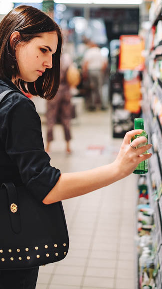 Young woman choosing care cosmetic in a supermarket. shopping