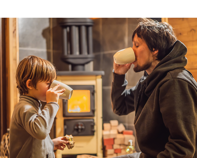 Dad and son spend time by the fireplace in Glamping. Rest in the mountains in Glamping. Cozy fireplace in a mountain house