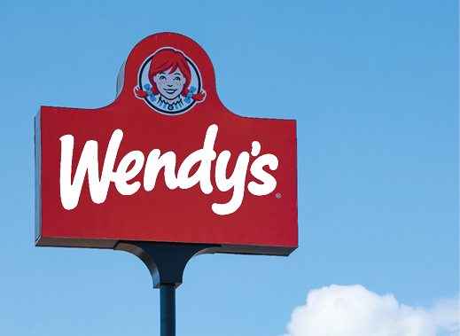 Las Vegas, NV 2-13-2021: Big sign of Wendy’s fast food restaurant at its location on W Sahara Avenue. The chain is headquartered in Dublin, Ohio. Isolated on blue sky with clouds in the background.
