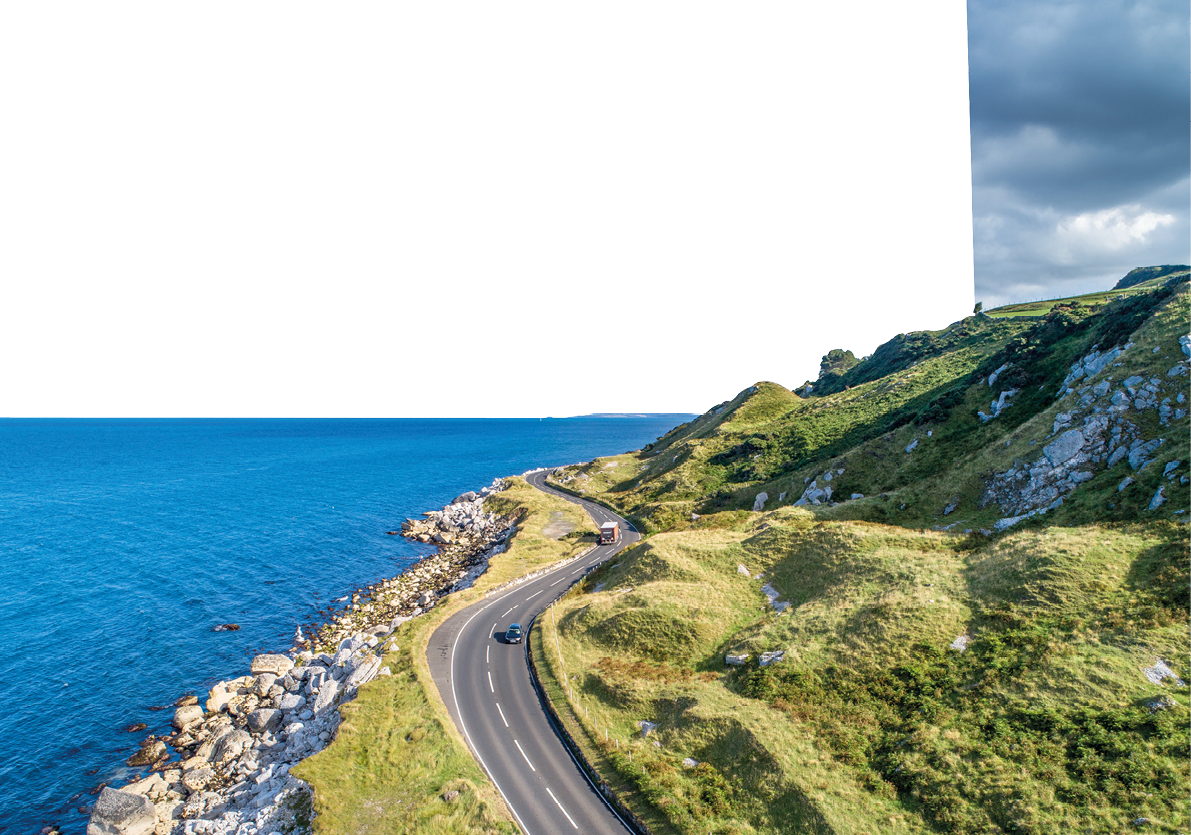Causeway Coastal Route with cars, a.k.a. Antrim Coastal Road on eastern coast of Northern Ireland, UK.
