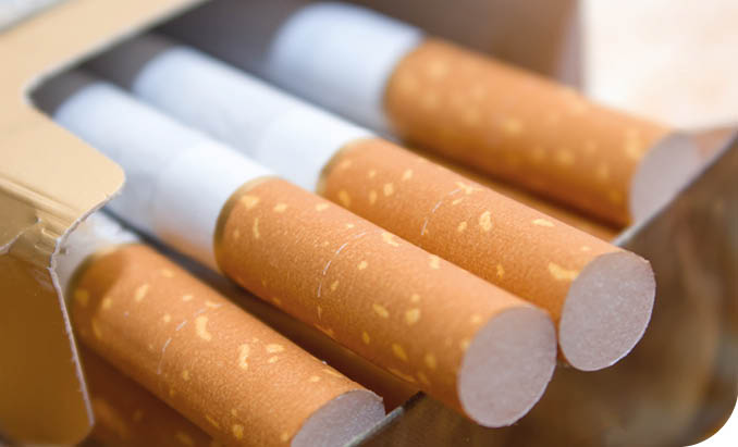 Cigarettes in a pack. Yellow filter. Harm to health. Bad habit. A pack of cigarettes on the table. open pack of cigarettes.