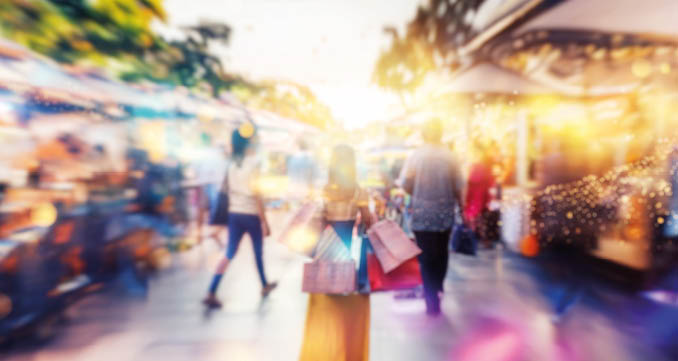 A blurred view of people walking along a shopping street.
