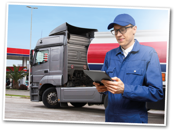 Man with digital tablet on a background of gasoline truck with tank trailer and a gas station