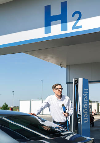Man holds a hydrogen fueling nozzle on a hydrogen filling station. Refueling car with hydrogen fuel. 