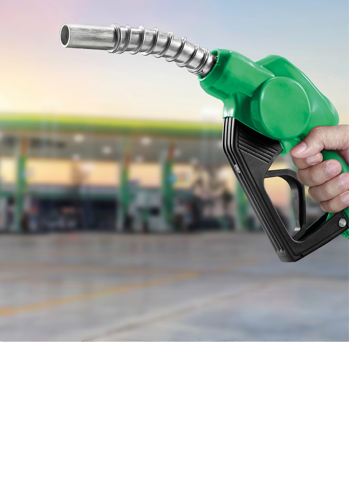 Holding a fuel nozzle against with gas station blurred background