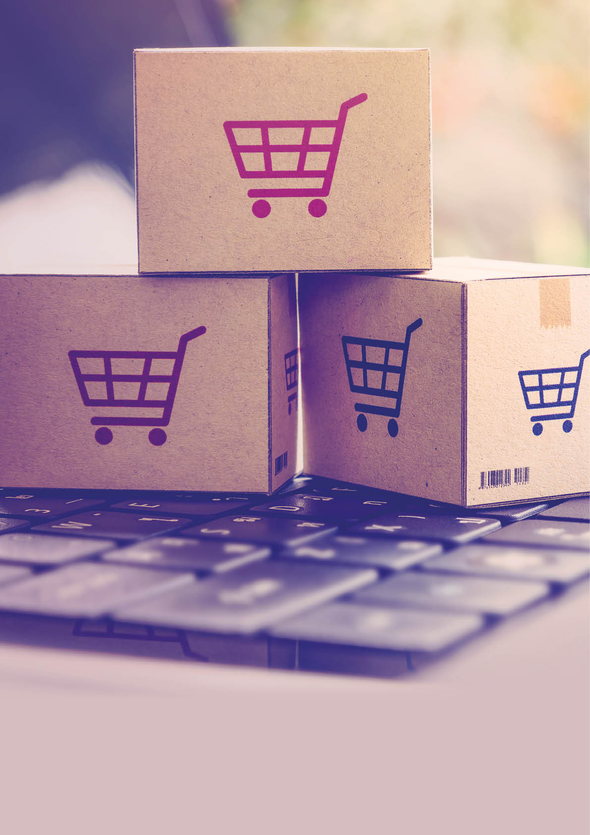 Online shopping / ecommerce and delivery service concept : Paper cartons with a shopping cart or trolley logo on a laptop keyboard, depicts customers order things from retailer sites via the internet.