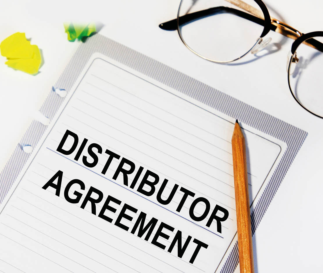 On a sheet from the diary inscription DISTRIBUTOR AGREEMENT, next to it is a pencil, glasses.